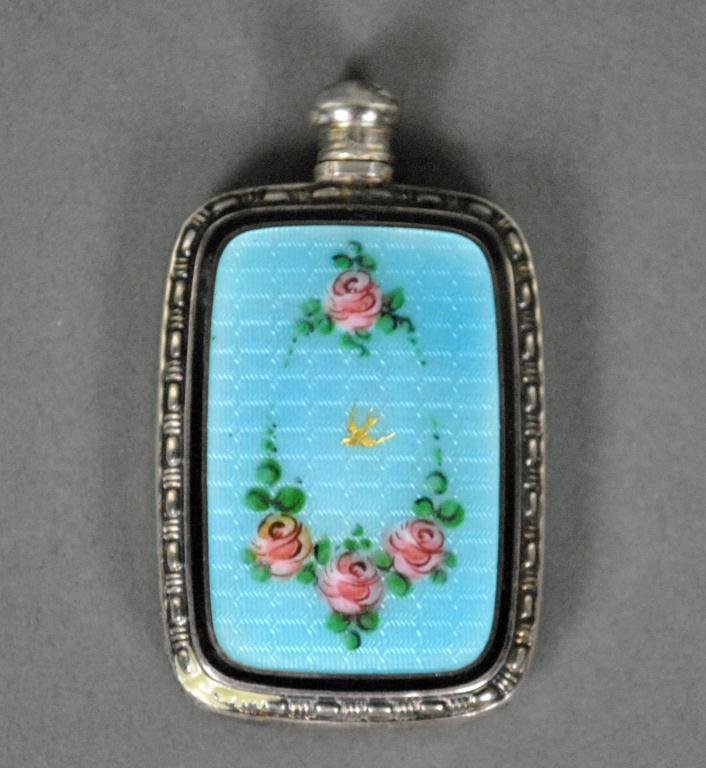 STERLING AND GUILLOCHE ENAMEL MINIATURE PERFUME: the face having rose swag decoration surrounding a gilt bird on a blue enameled panel, the reverse monogrammed HW, 2in.