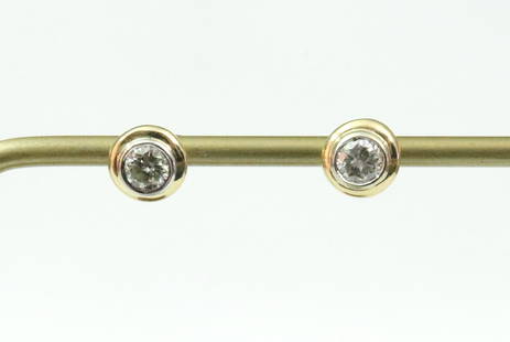 PAIR 14K DIAMOND STUD EARRINGS: each featuring a round bezel-set diamond approx. 0.30ct (in our opinion: H-I color, VS2 clarity, however not guaranteed), in yellow gold (one with tiny gold pinhole observed under loupe inspection), t