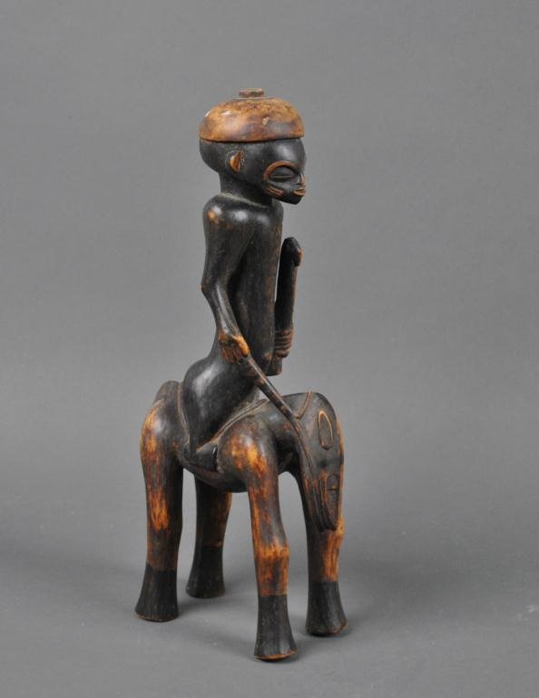 CARVED AFRICAN TRIBAL ART - EQUESTRIAN FIGURE: depicted holding a staff in one hand, a bridle rope in the other, polychromed decoration, 15in.