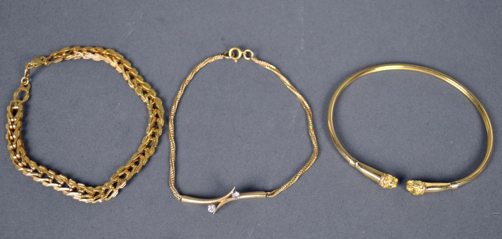 THREE GOLD BRACELETS: including a bangle with lion head terminals, a 7" Italian chain link bracelet, and a 7" herringbone bracelet set with 2 diamond melee, all marked 14K, 14.7gms.