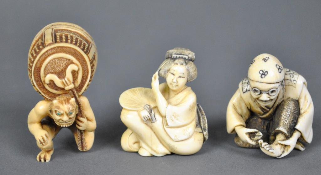 THREE JAPANESE CARVED IVORY NETSUKE: including a gent cutting his toe nails, a seated geisha, and an oni carrying Benkei's bell NO INTERNATIONAL SHIPPING.