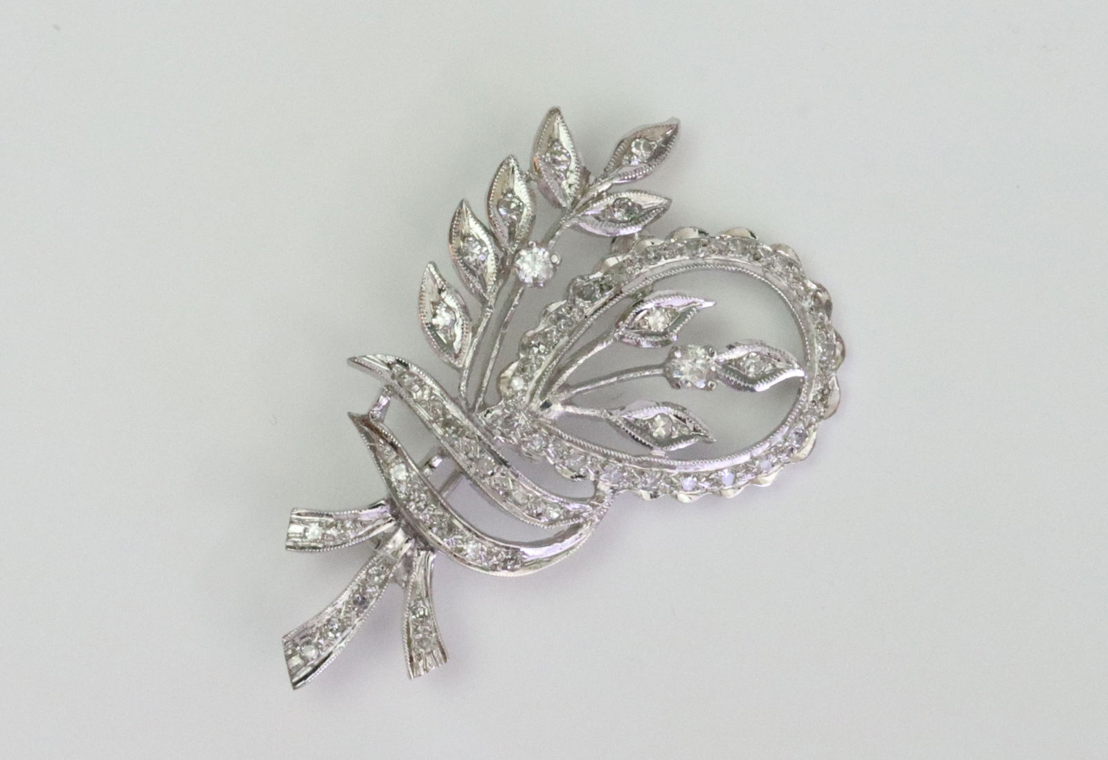 14K DIAMOND SPRAY PIN: set with 50 round natural diamonds approx. 0.60ctw, in white gold, tests 14K, 1.5in., 6gms., Opening Bid $200