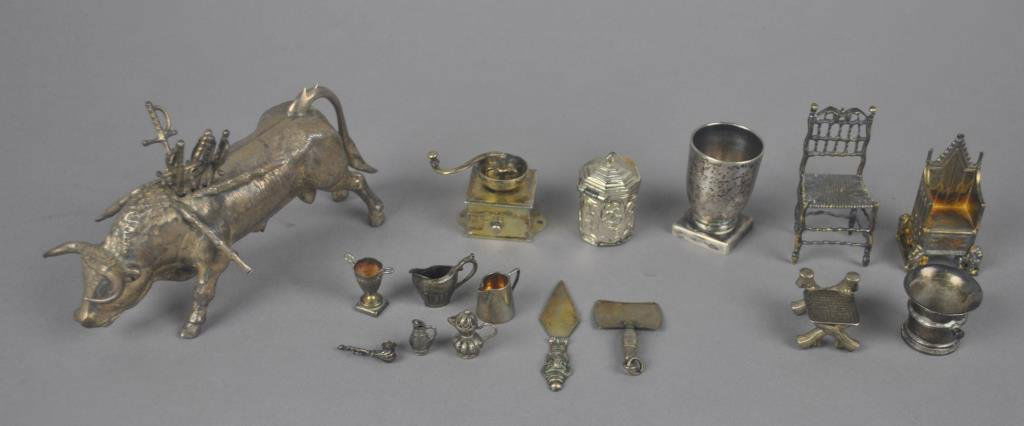 16-PIECE SILVER AND SILVERTONE MINIATURE GROUP: including an unmarked bull toothpick holder (likely silver), a throne chair marked English Sterling, an X-frame chair marked Sterling, an English hallmarked pitcher, another pitcher marked Sterling, a