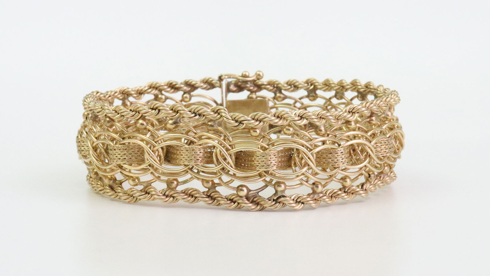 14K FANCY LINK BRACELET: designed in parallel and stocking mesh link with rope trim, has a touch of flexibility, width 20mm, length 7.25in., stamped 14K, safety catch, 42.6gms., Opening Bid $2500