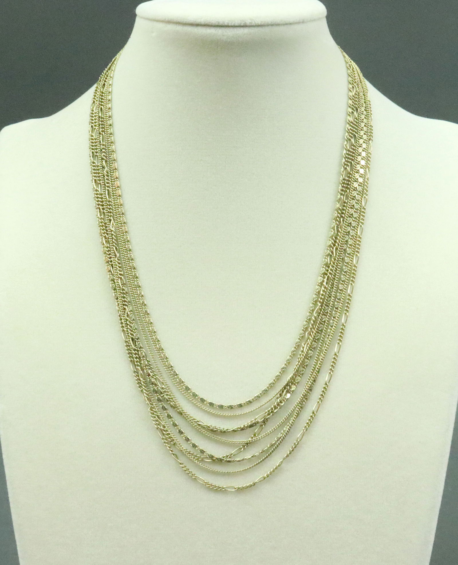 14K MULTISTRAND CHAIN LINK NECKLACE: comprising 9 strands in curb, scroll and figaro links, stamped '14ct Germany', 16.75in., double safety, 34.4gms., Opening Bid $1900