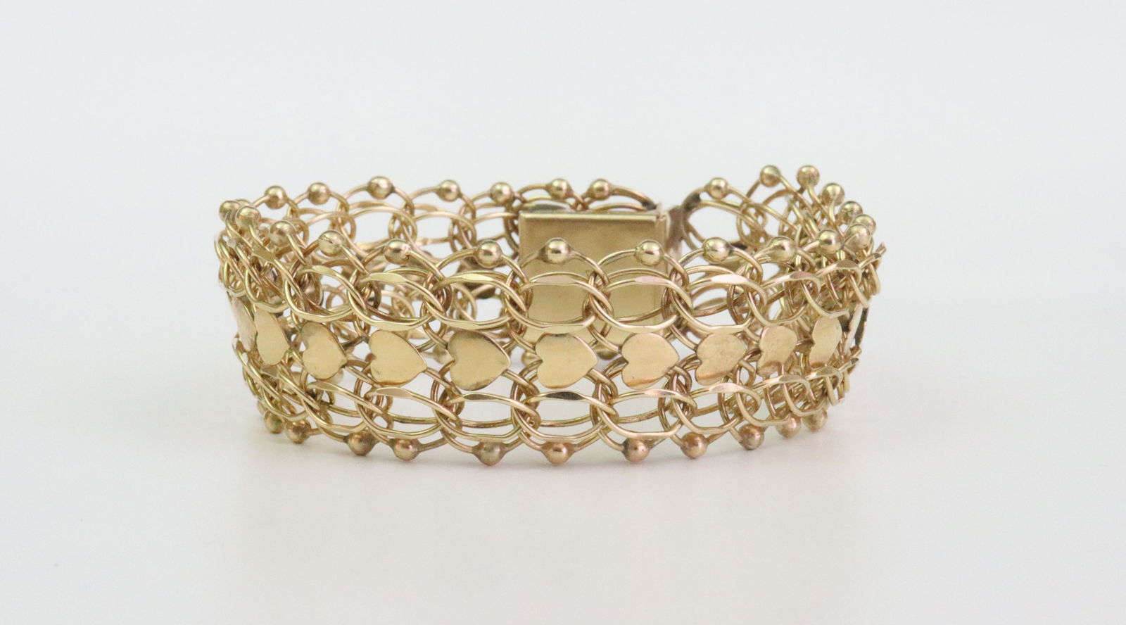 14K FANCY HEART LINK BRACELET: designed in parallel and heart link with bead trim, has a touch of flexibility, width 20mm, length 7.5in., stamped 14K, safety catch, 28.3gms., Opening Bid $1700