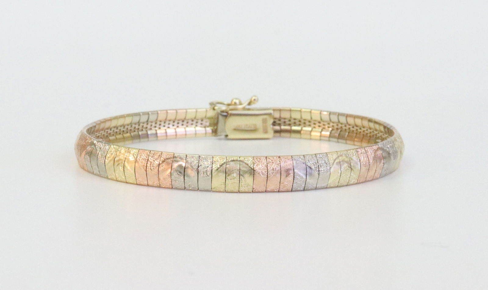 ITALIAN 14K TRICOLOR OMEGA FLEX BRACELET: in diamond-cut wave design, stamped 'Italy 14Kt Milor', width 5.8mm, length 6.75in., safety catch, 12.7gms., Opening Bid $600
