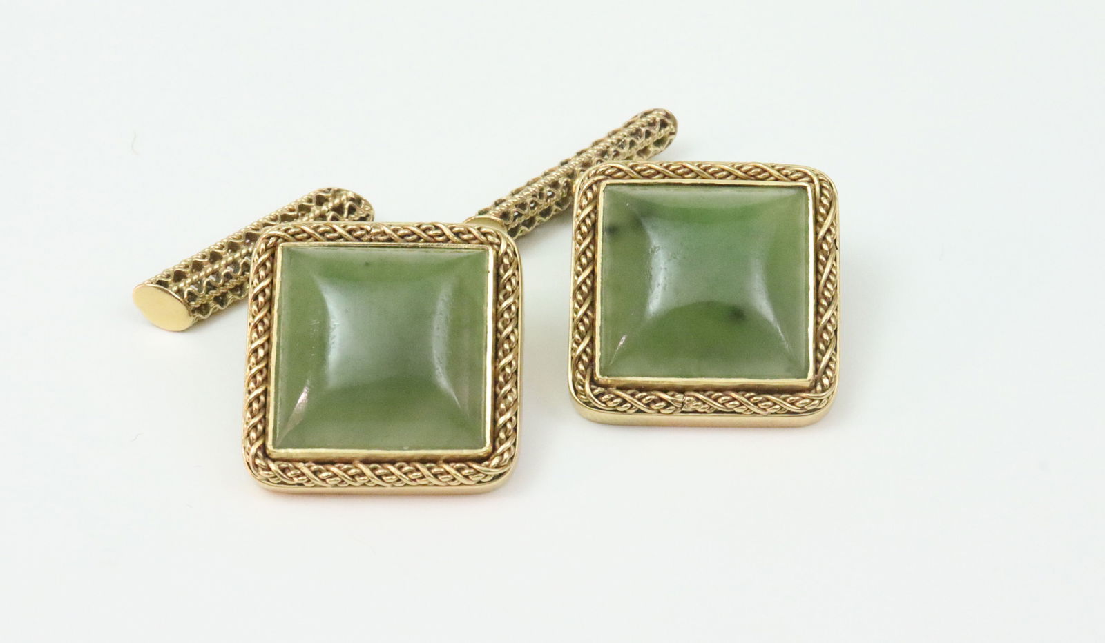 PAIR 18K NEPHRITE JADE CUFFLINKS: overall face 20x20mm with twist rope trim, chain link toggle backs, in yellow gold, test 18K, gross weight 17.7gms., Opening Bid $600