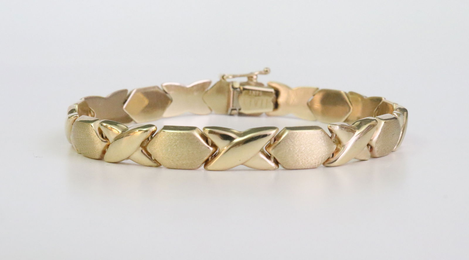 ITALIAN 14K HUGS AND KISSES BRACELET: in yellow brushed and polished gold, stamped '14Kt Italy', width 7mm, length 7in., 11.3gms., Opening Bid $600