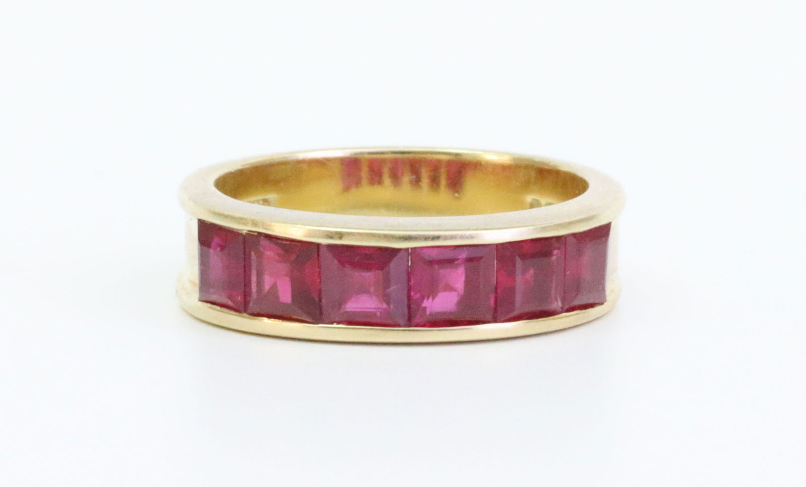 18K RUBY BAND: featuring 6 channel-set square cut rubies (4x4x2.4mm) approx. 2.10ctw, in yellow gold, British hallmarks for 750, London and 1993, and with maker's mark TO'D (Tom O'Donoghue), size 7, 7.1gms.,