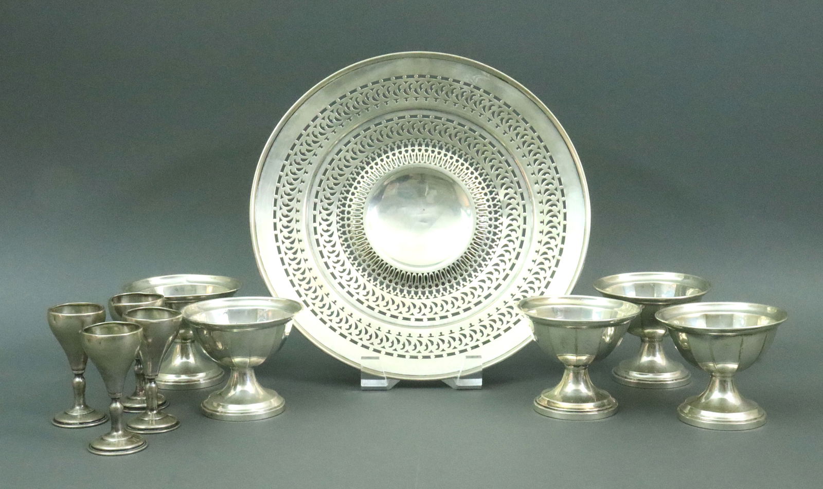 (10) PIECE STERLING TABLEWARE GROUP: including a pierced tray, 10.25in., 4 cordials, 3in. (small dents), and 5 weighted sundae cups (one with repair), 3in., 10.1ozt. weighable silver, weighted stems 14.2ozt., Opening Bid $400