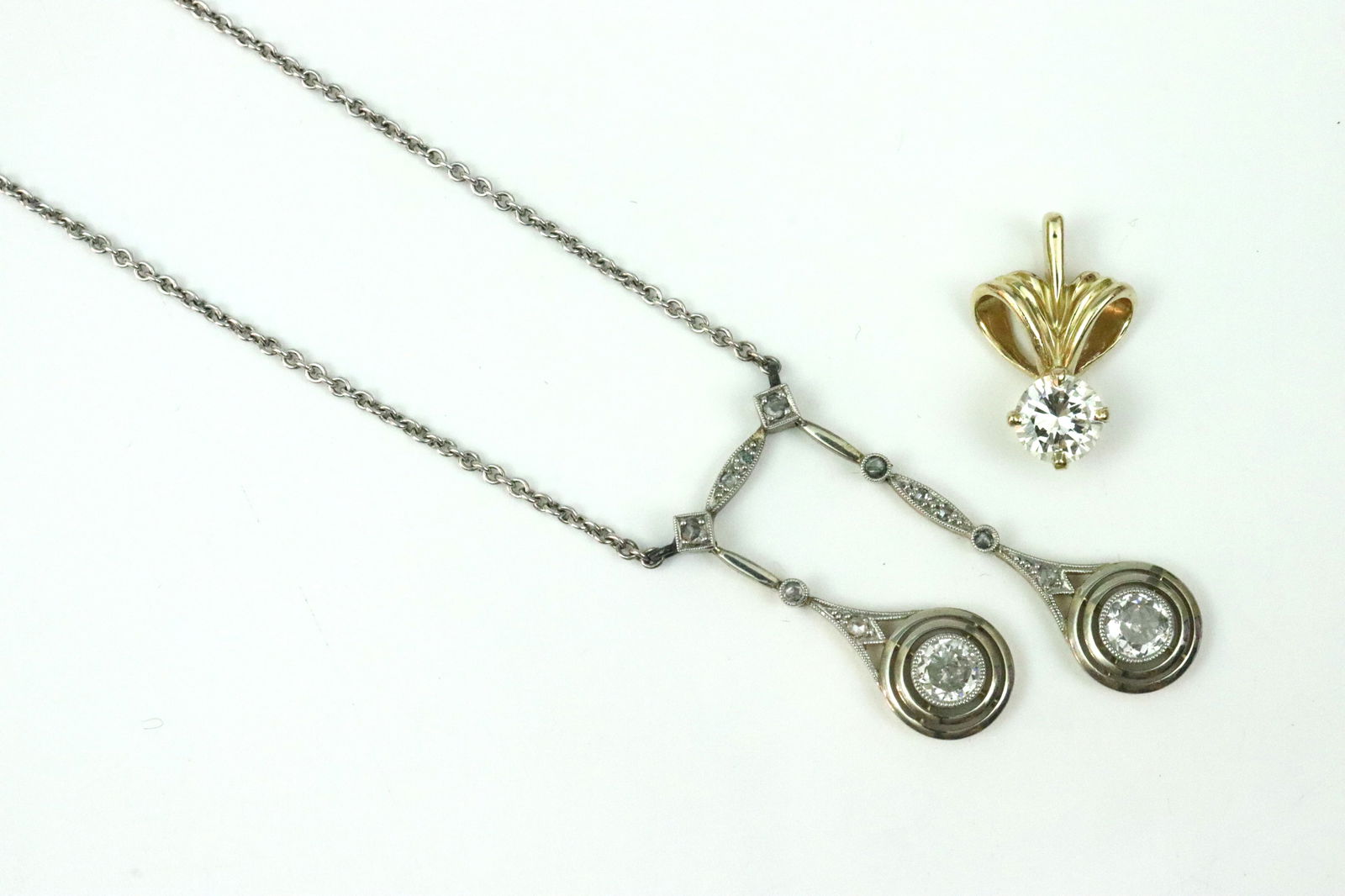 (2) 14K DIAMOND PENDANTS, ONE REPURPOSED ON CHAIN: comprising a repurposed Art Deco double drop pendant set with 2 round (25pt) diamonds accented with 9 rose cut diamonds, affixed on later 18in. cable chain (solder remnants at likely added attachment