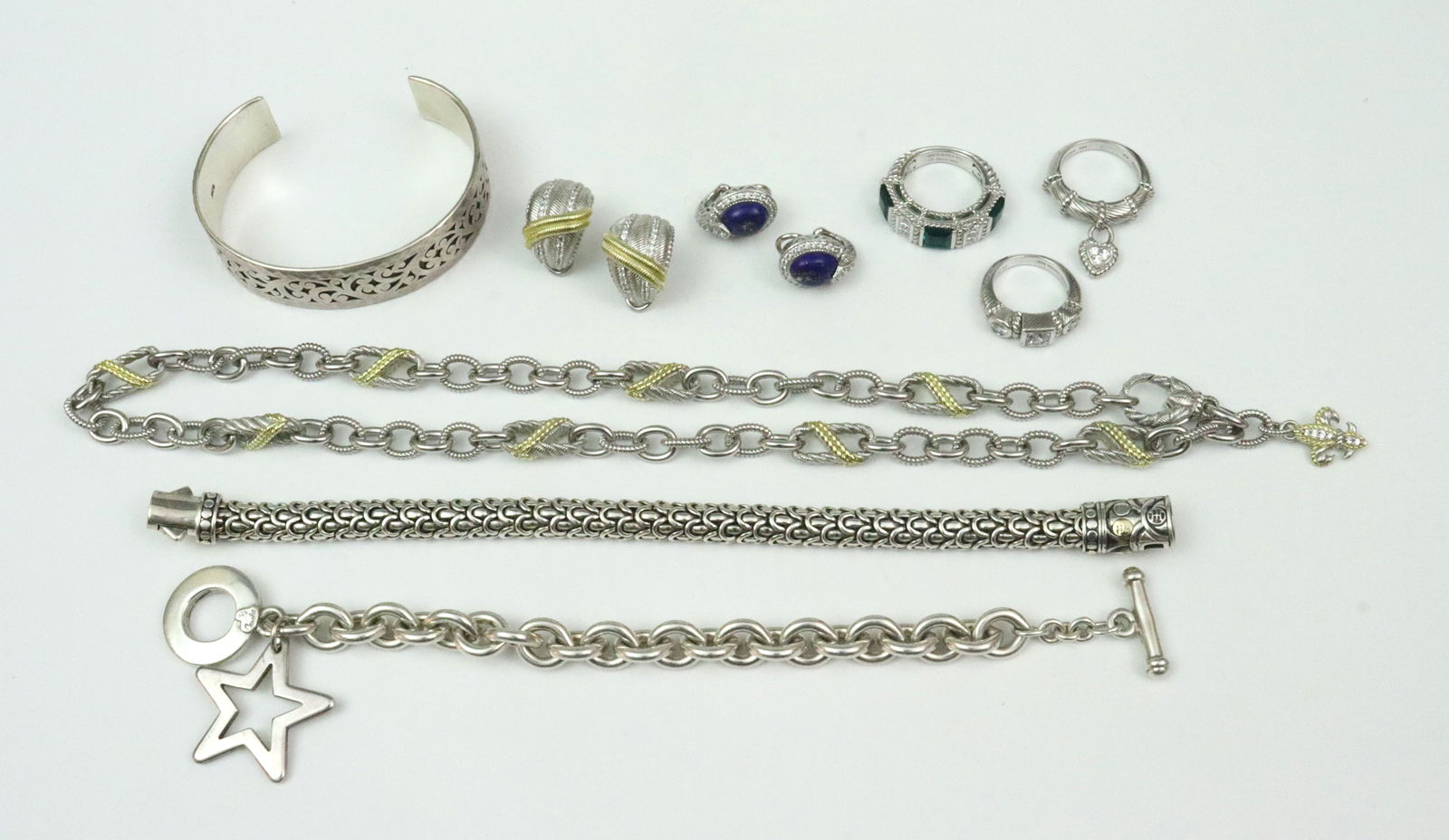 RIPKA, HARDY, HILL & CAROLEE 925 JEWELRY GROUP: 9 pieces, 6 Judith Ripka jewelries all accented with white CZ stones, includes a 20" 2-tone figaro necklace with fleur de lis charm, a pair of similar 18mm 2-tone huggie ear clips, a pair of 18mm