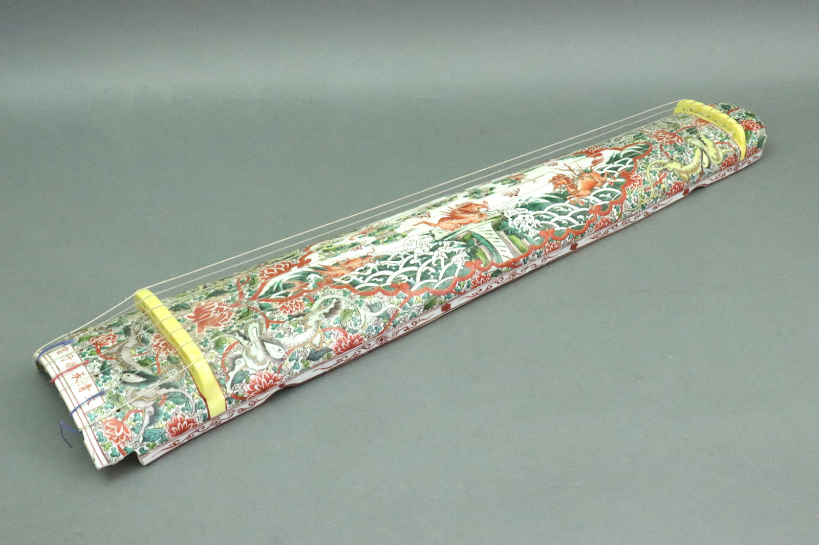 CHINESE FAMILLE VERTE GUZHENG: porcelain instrument evolved from the earlier zither, in dragon and floral motif, bears apocryphal six character Qianlong reign mark of the Ching Dynasty (1735-1796), not of the period, likely