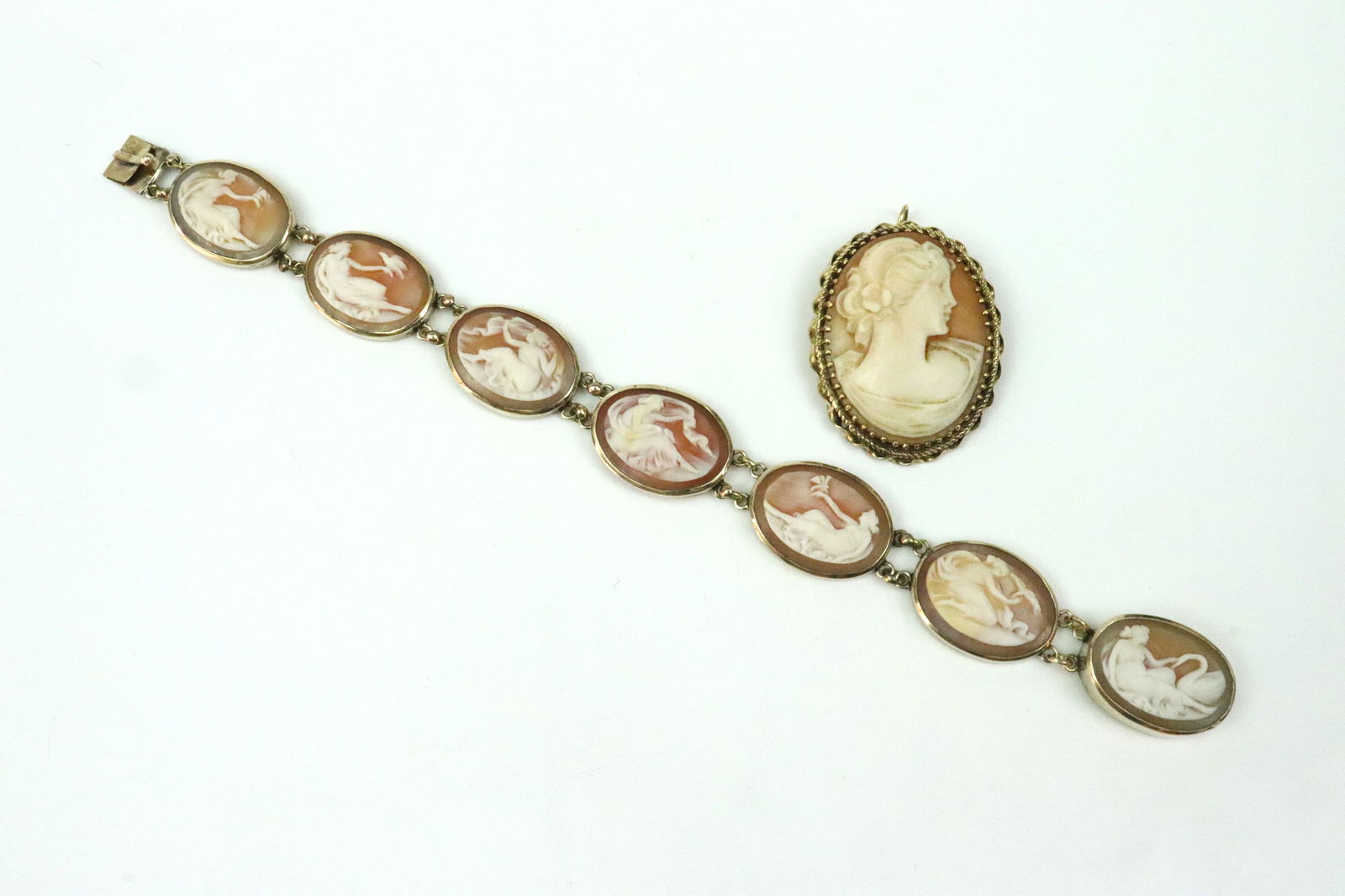 14K CAMEO PIN & BRACELET: including a portrait cameo pin with hinged bale to also serve as a pendant, 1.3in., and a 7-panel chain link cameo bracelet in classic scenics, width 15mm, length 6.5in., each in yellow gold stamped