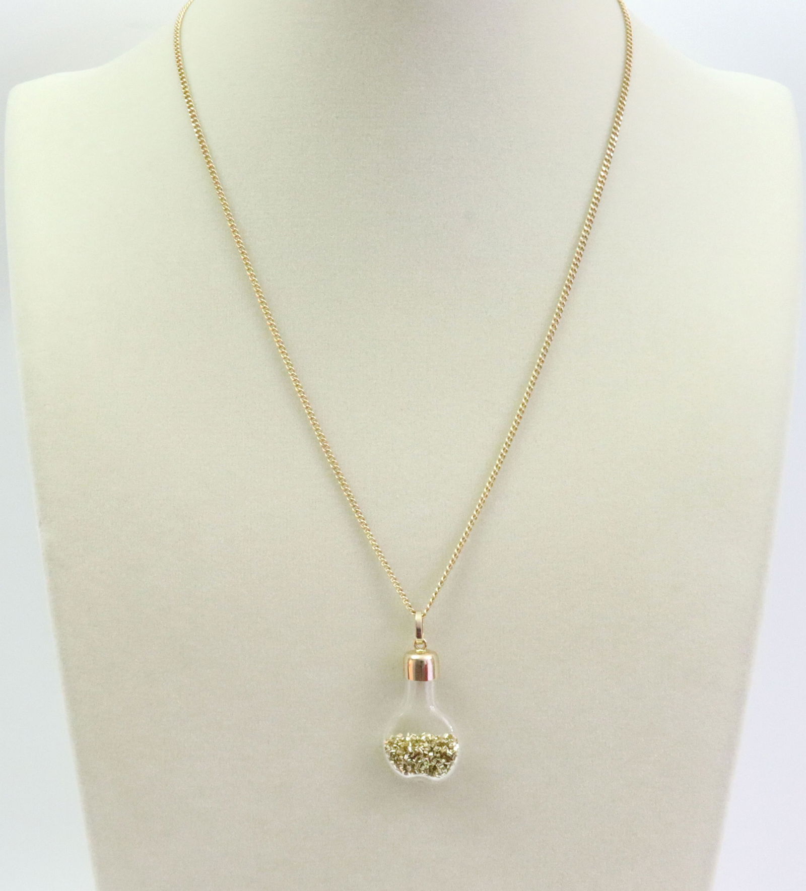 14K CURB LINK CHAIN WITH 14K GOLD DUST PENDANT: comprising a curb link neckchain stamped '14K Italy', 18in., 5.4gms., and a glass gold dust flask pendant with 14K cap and bale, 1.4in. including bale, 2.9gms., gross weight 8.4gms., Opening Bid $300