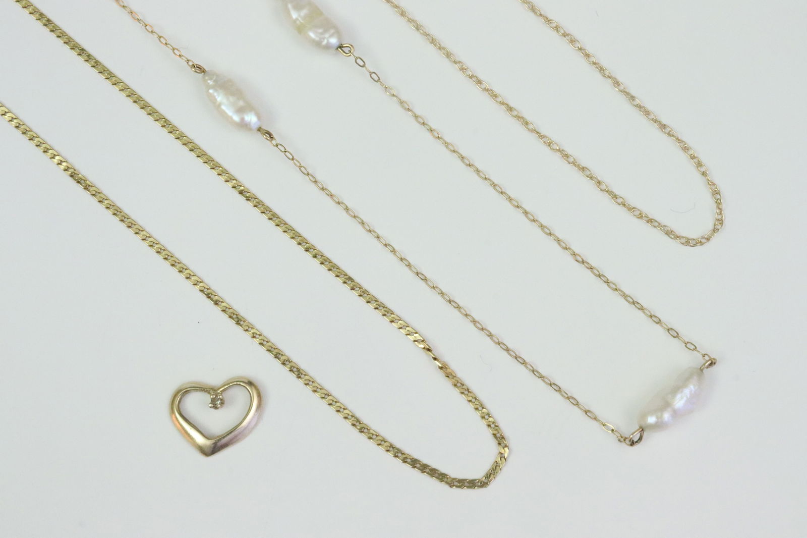 (4) PIECE 14K JEWELRY GROUP: including a 24" cable chain with keshi pearl stations, a 20" herringbone chain (some minor kinks), an 18" parallel link chain, and an 11mm floating heart pendant charm with diamond accent, all