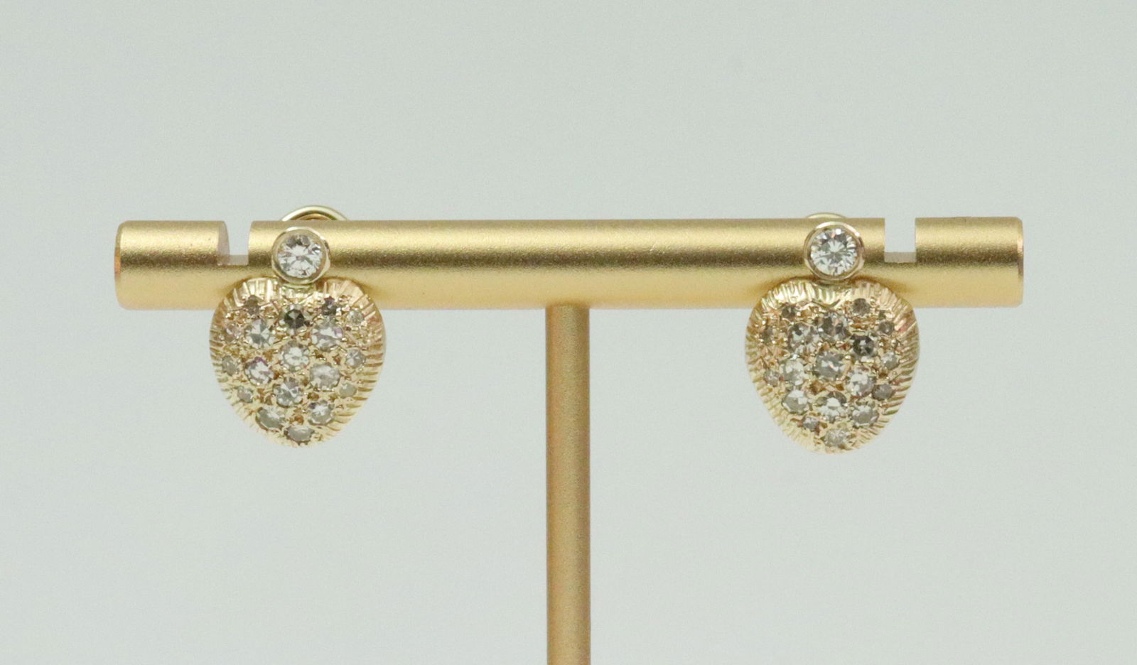 PAIR 14K DIAMOND HEART STUD EARRINGS: each comprising a round bezel-set diamond surmounting 18 pave-set round diamonds, total diamond weight for the pair approx. 1.00ctw, in yellow textured gold, stamped 14K, clip-post backs, 15x11mm,