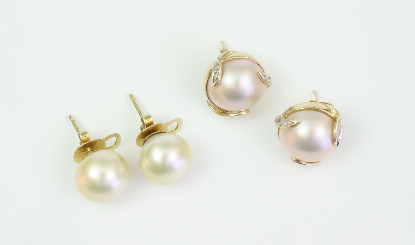 (2) PAIRS 14K CULTURED PEARL STUD EARRINGS: including a pair of mabe pearl button earrings each accented with 6 melee diamonds (adhesive remnant to backsides, posts with some bending), overall 16mm, stamped '14K 585', mismatched earring backs