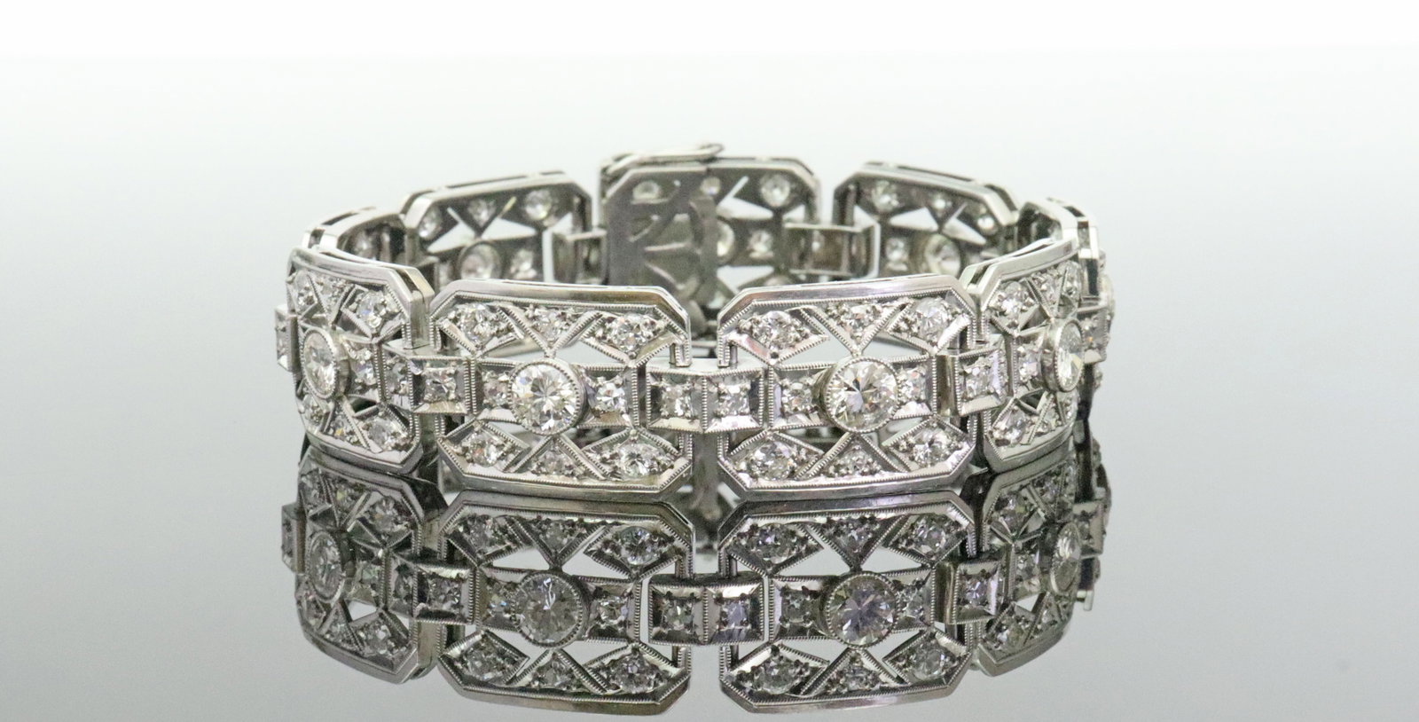 ART DECO PLATINUM & DIAMOND BRACELET 7.25CTW: designed in 9 articulated links set with 99 round diamonds approx. 7.25ctw (in our opinion: G-H color, VS-SI clarity, however not guaranteed), each link centering a (35pt) bezel-set diamond, width 15m