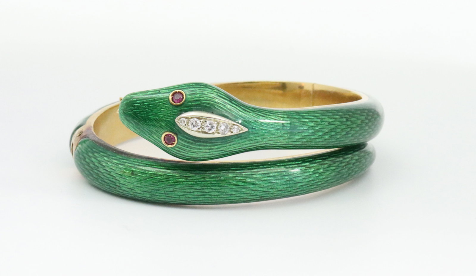 ITALIAN 18K DIAMOND, RUBY & ENAMEL SNAKE BANGLE: double hinged, designed as a coiled snake in green guilloche enamel, the head adorned with 5 round natural diamonds approx. 0.20ctw, ruby-set eyes, in yellow gold, stamped 750, and with Italian hallma
