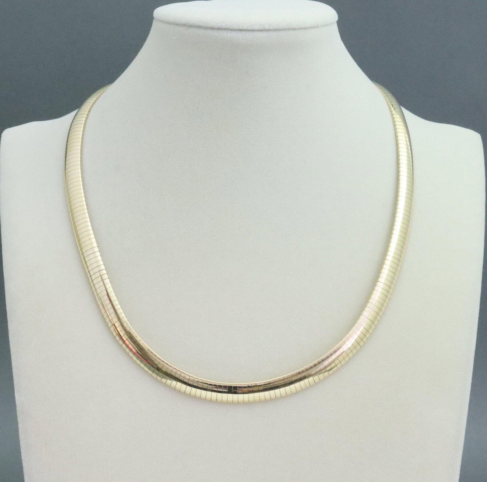 14K OMEGA NECKLACE: in yellow gold, stamped 'BBK 14K', width 8mm, length 17in., 50.1gms., Opening Bid $2500