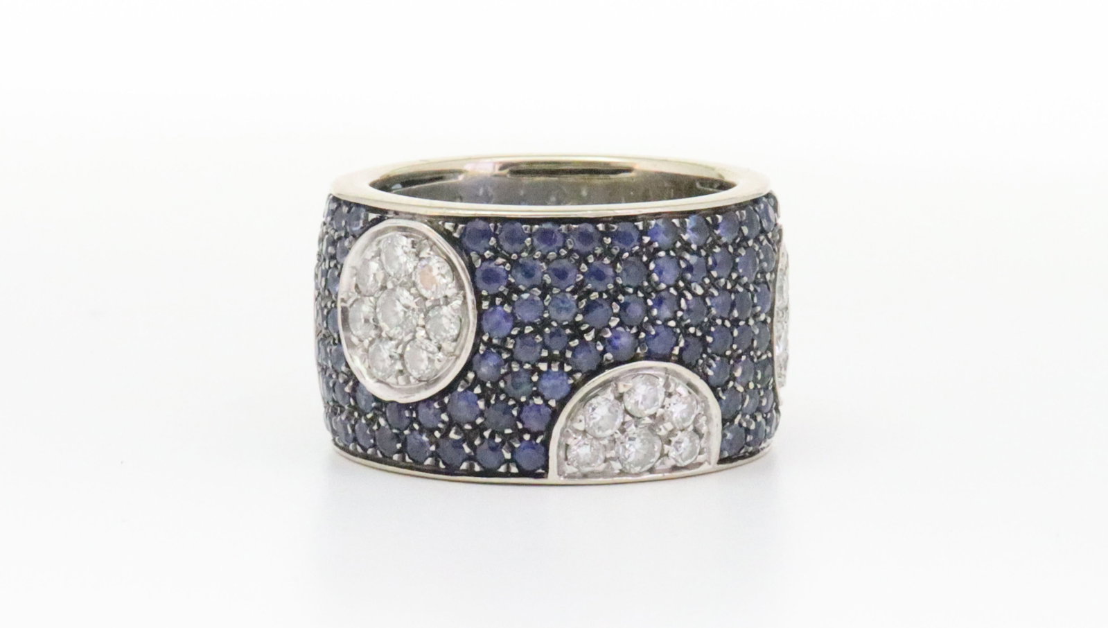 ITALIAN 18K DIAMOND & SAPPHIRE WIDE BAND RING: the band designed with 145 pave-set sapphires approx. 2.90ctw, embellished with 5 circular and semi-circular natural diamond clusters comprising a total of 35 round cut diamonds approx. 1.20ctw, the