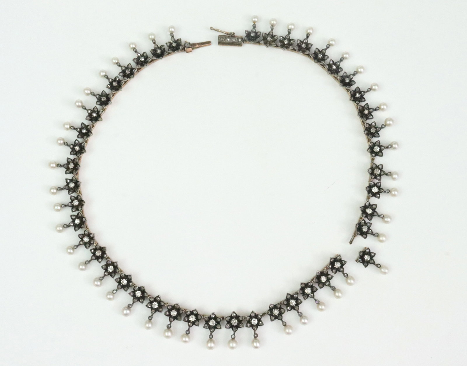 ANTIQUE SILVER-TOP ROSE CUT DIAMOND & PEARL CHOKER: in as-is condition with central cable broken (see images), the floral segmented choker comprising 365 rose cut diamonds and 45 stationary pearl drops, total weight of diamonds at rough estimate