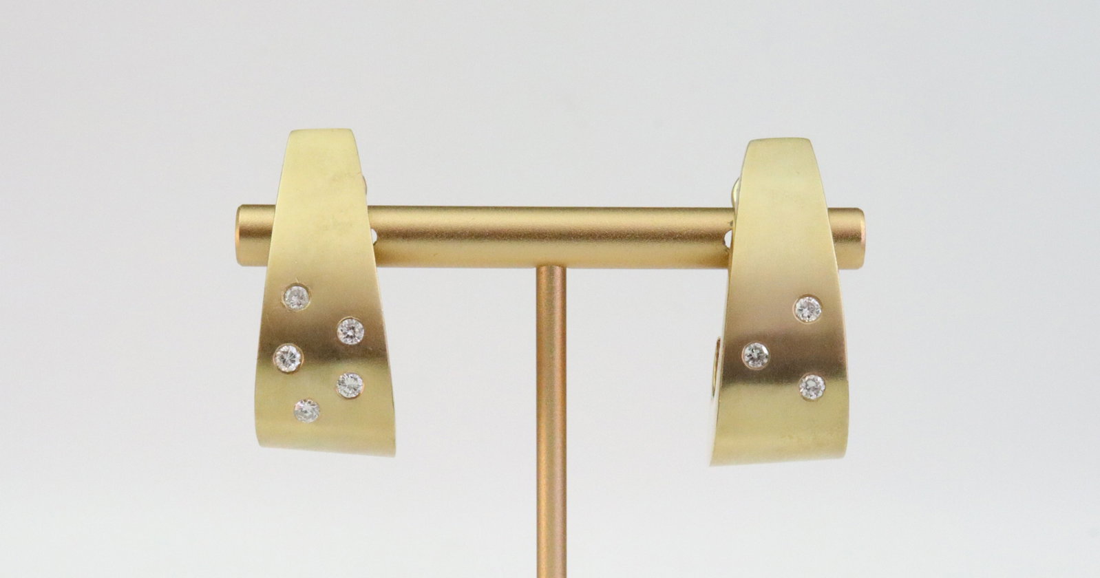 PAIR 14K J-HOOP EARRINGS WITH DIAMONDS: designed in contemporary asymmetrical style with one earring bezel-set with 5 natural diamonds, and the other bezel-set with 3 natural diamonds, total diamond weight for the pair approx. 0.40ctw, in