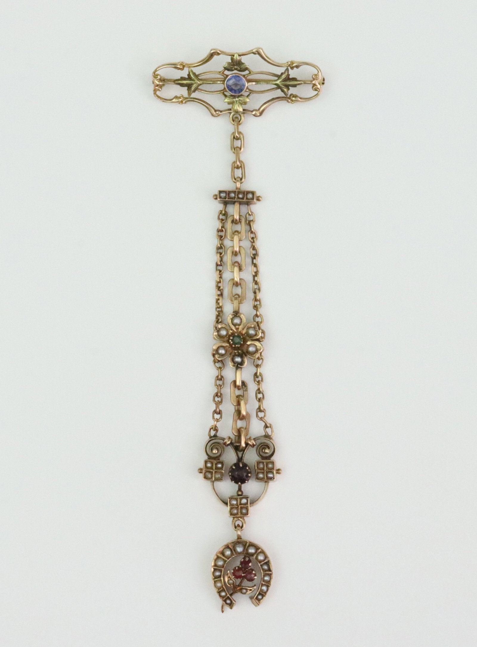 REPURPOSED GOLD & GEMSTONE DANGLE PIN: comprising a 10K openwork bar pin suspending a 14K 3-row chatelaine, gemstones include garnets and seed pearls, in yellow gold, all aptly stamped or tested, overall length 4.5in., 11.2gms., Opening