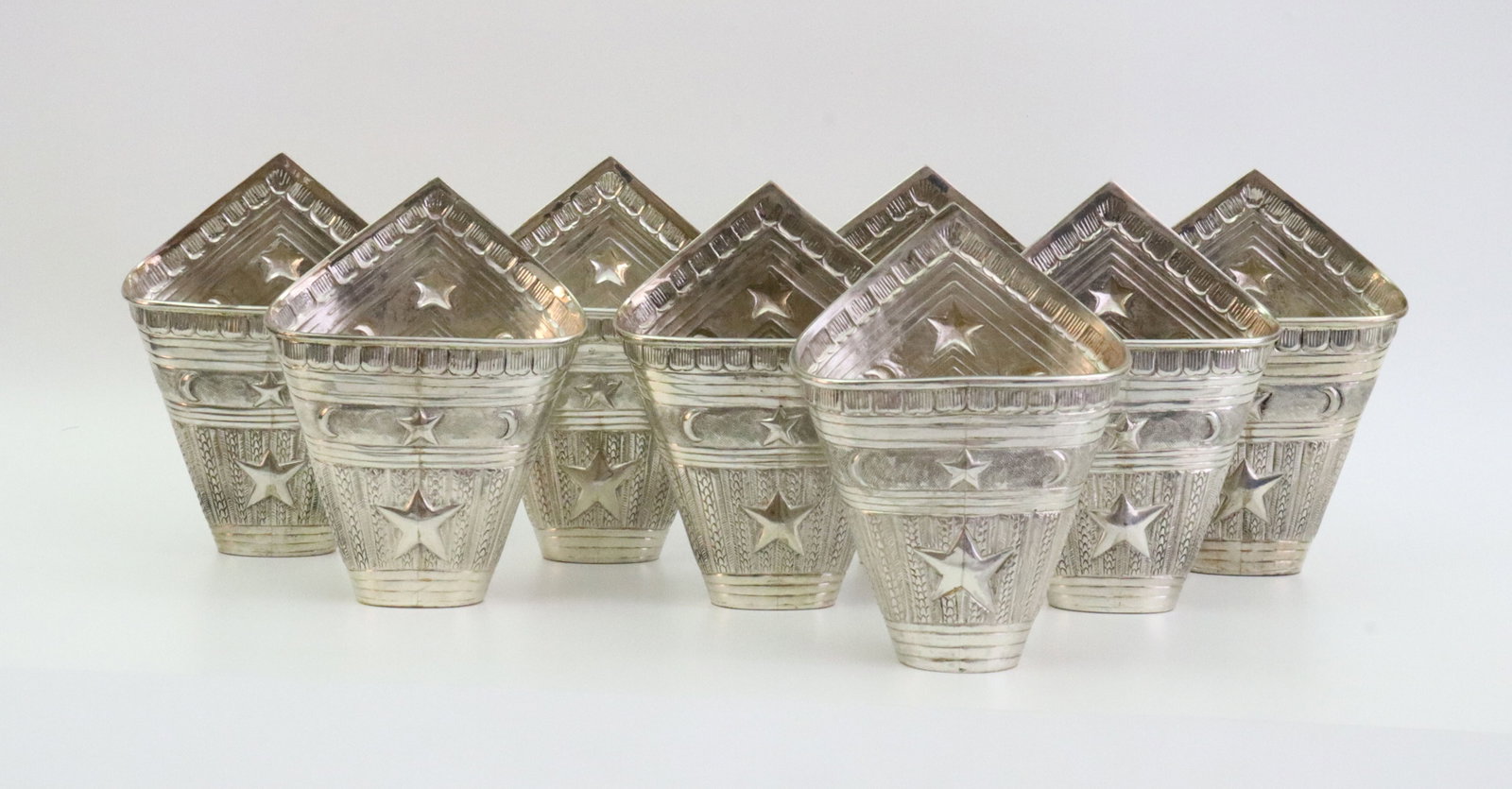 SET OF 8 STERLING BETEL LEAF HOLDERS: with allover star, crescent moon and incised leaf decoration, stamped 'Sterling 925', and with unknown makers mark (see image), 4.5x3.25in., 19.6ozt., Opening Bid $800