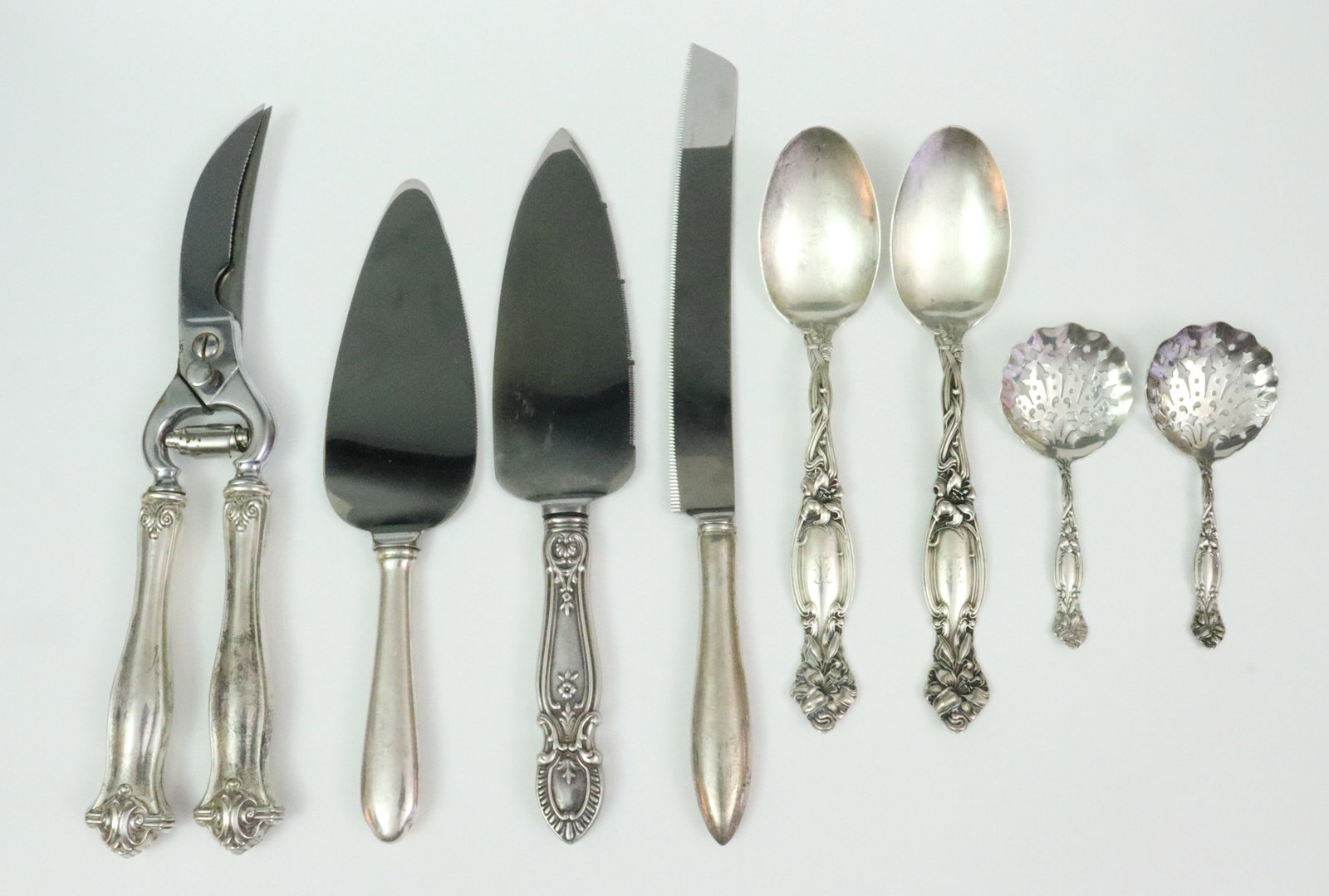(8) STERLING SERVICE PIECES: including 2 small serving spoons (8.2in.) and 2 bonbon spoons (4.5in.) by International Silver, and 4 sterling-handled service pieces including a Cartier cake knife (12in.), a Web pie server (9.5in.),