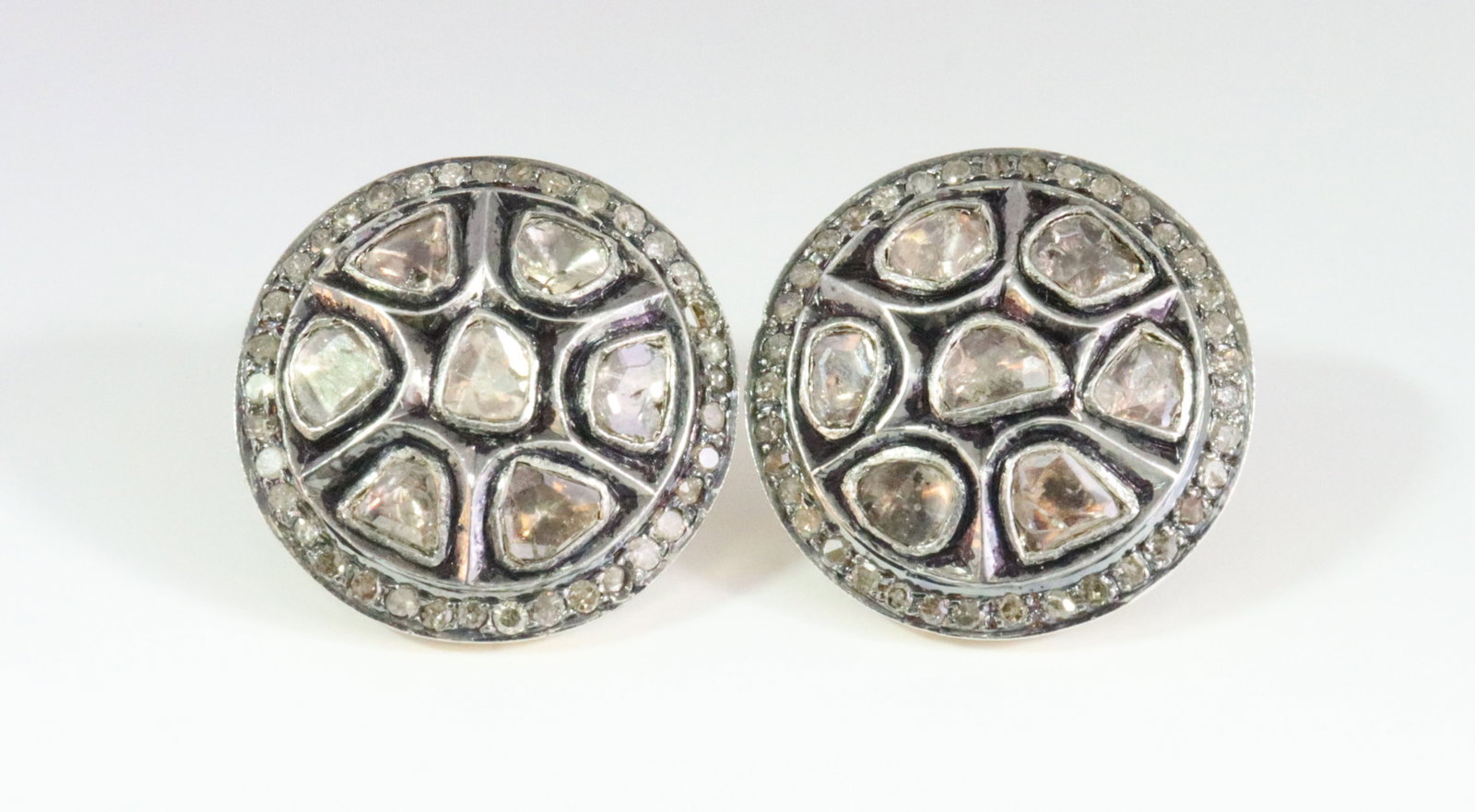 PAIR ANTIQUE 14K SILVER-TOP POLKI DIAMOND EARRINGS: in button style, each comprising 7 (avg. 4x5mm) bezel-set polki diamonds within a surround of 37 melee diamonds (one melee diamond missing), oxidized darkened patina finish to mountings (typical