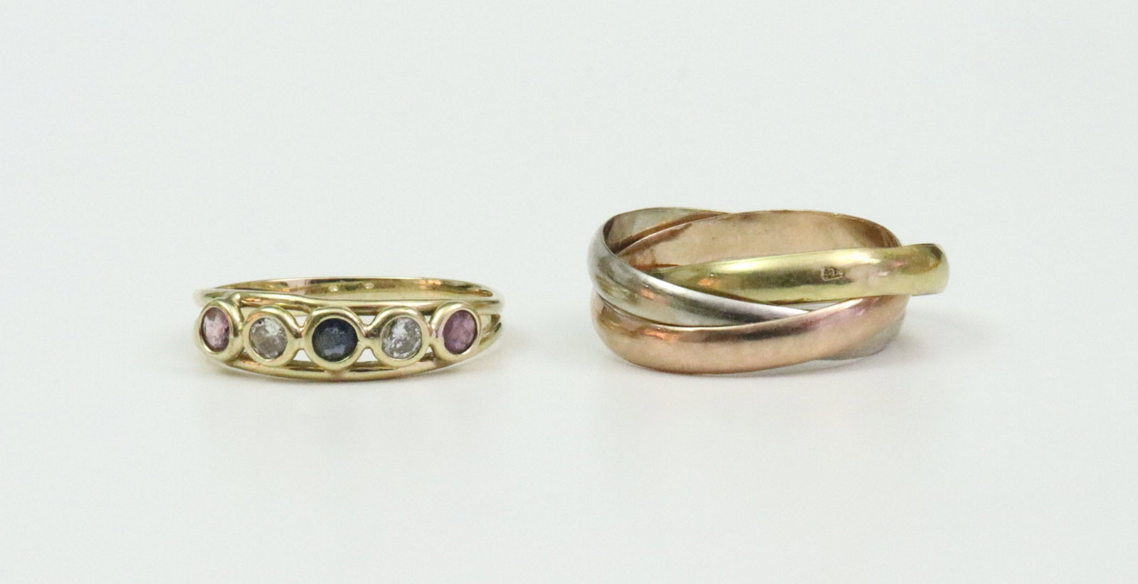 (2) 14K RINGS: including a trinity ring comprising 3 intertwined moving rings in yellow, white, and rose gold, stamped 14K, size 6.25, 4.6gms., and a 5-stone gemstone ring approx. 0.30ctw (in our opinion- sapphire, 