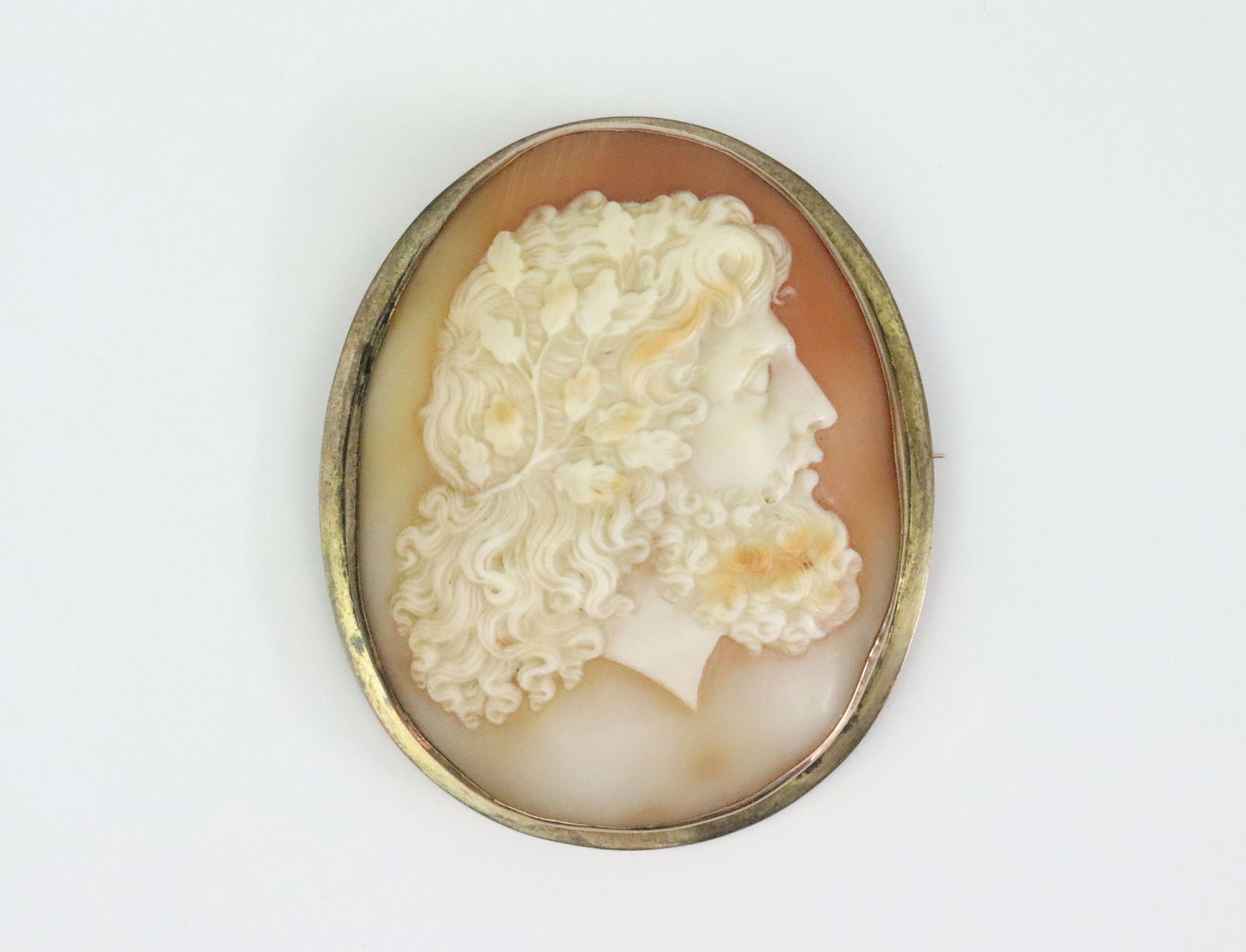 LARGE VICTORIAN CAMEO BROOCH OF ZEUS: carved shell cameo of large size with the Greek god Zeus depicted in profile, tests low gold (likely 8-9K), frame with some wear and tarnish, shallow edge dent to the reverse at bottom, cameo