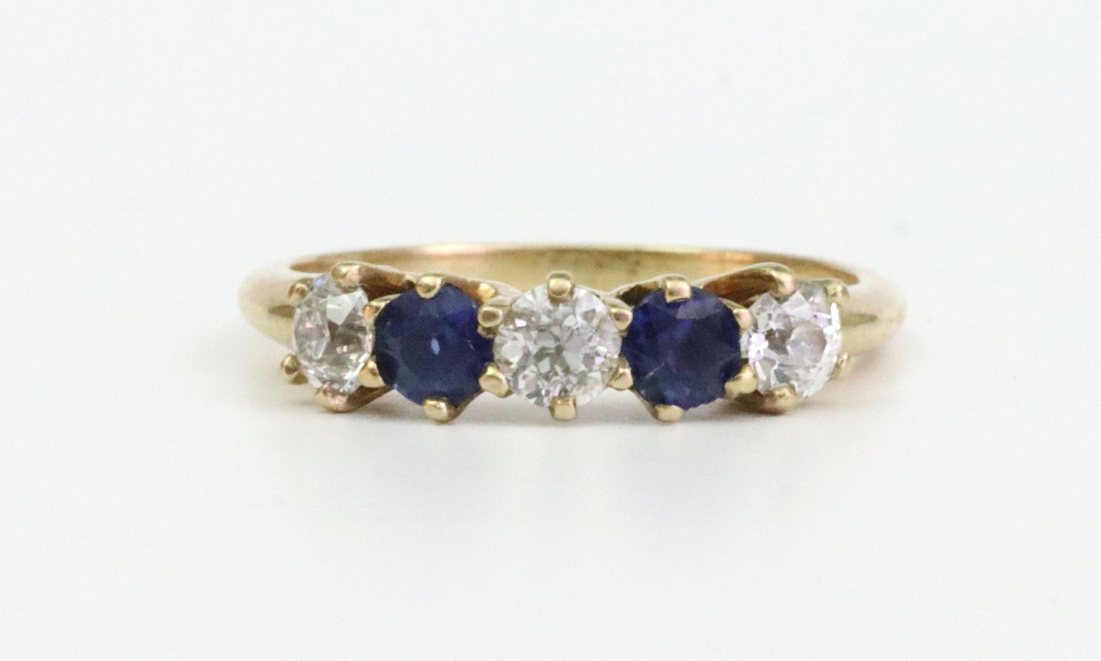 14K DIAMOND & SAPPHIRE 5-STONE RING: set with 3 round natural diamonds (in our opinion: E color, VS clarity, however not guaranteed), and 2 round sapphires, total carat weight approx. 0.95ctw, in yellow gold, stamped 14K, size 6.25,