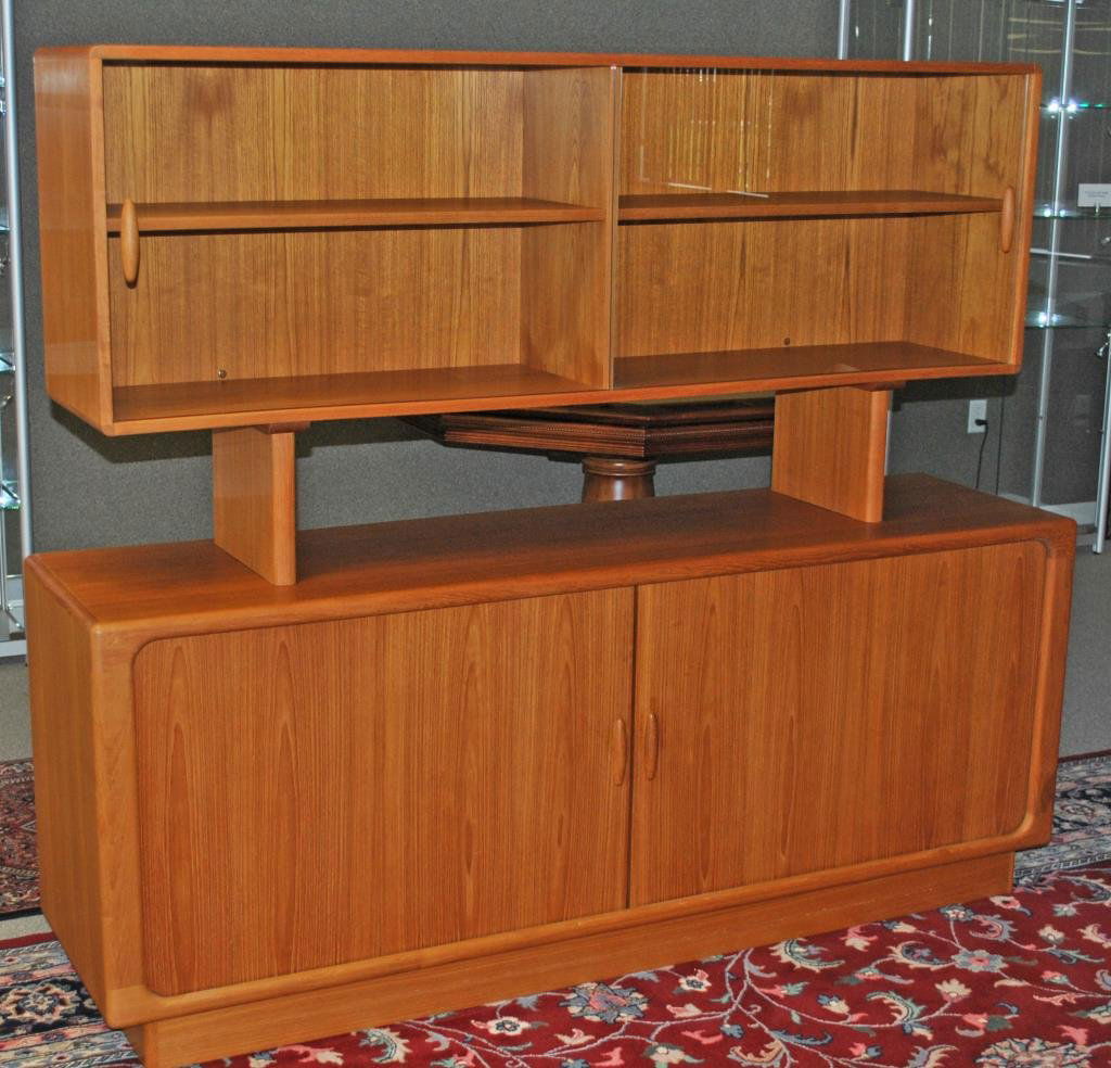DYRLUND DANISH TEAK TWO-PIECE SIDEBOARD CABINET: the upper case with sliding glass doors, the lower case with tambour sliding doors opening to an interior of drawers and shelves, on platform base, 'Dyrlund Made in Denmark' label verso, 63x74x19in.