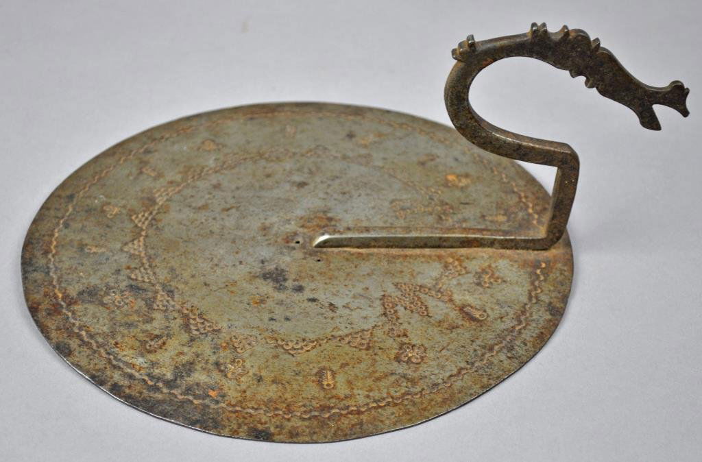 ANTIQUE IRON DISC: possibly a sun dial, with stipple decoration depicting various symbols, diameter 8in.