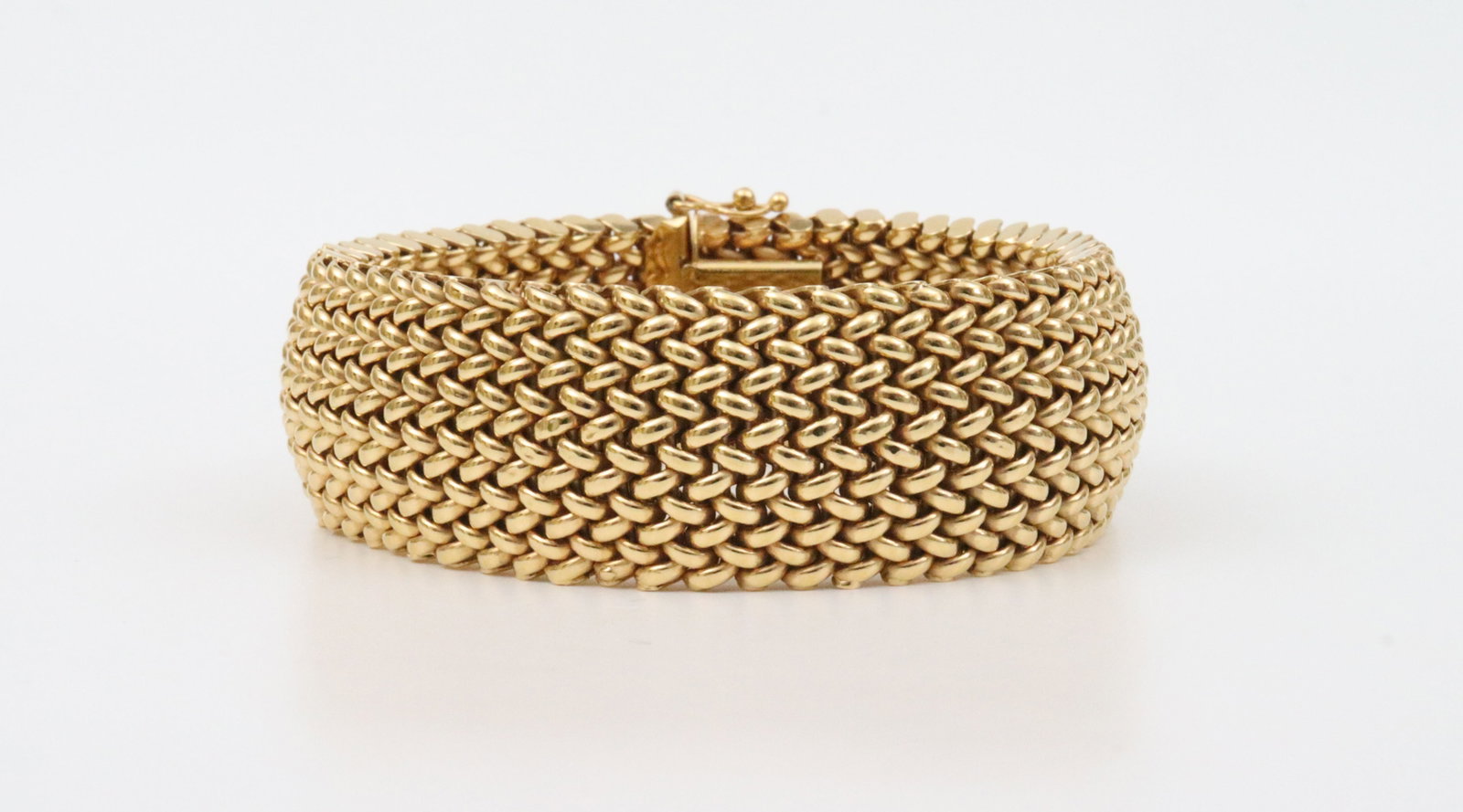 ITALIAN UNOAERRE 14K MESH LINK BRACELET: in flexible woven tubular design, width 20mm, length 7in., in yellow gold, stamped '14K Italy Unoaerre Brev', and with their Italian hallmark 1 AR (Arezzo), safety catch, 33.2gms., Opening Bid $1500
