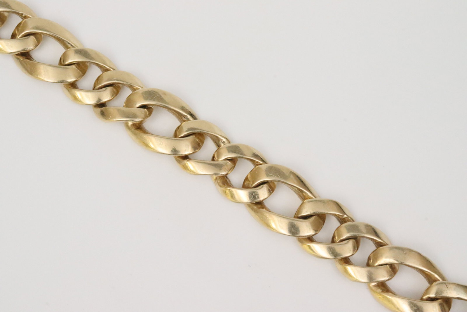 GENT'S 14K HEAVY CUBAN FIGARO LINK BRACELET: in yellow gold, stamped 14K, width 13mm, length 8.25in., safety catch needs repair, 63.6gms., Opening Bid $2800