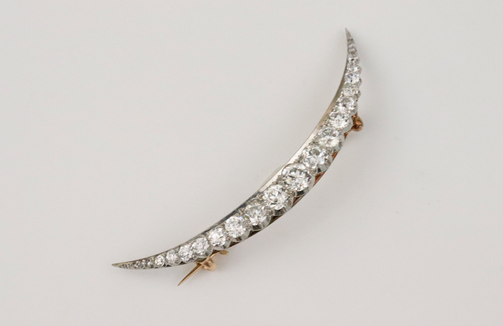 14K PLATINUM-TOP DIAMOND CRESCENT MOON PIN: set with 18 round European-cut graduated natural diamonds and 4 rose-cut diamonds approx. 2.10ctw (in our opinion: G-H color, SI clarity, however not guaranteed), largest diamond approx. 0.40ct,