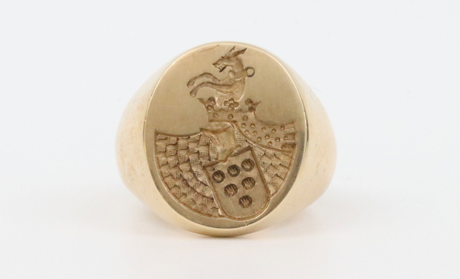14K FAMILY CREST SIGNET RING: featuring a heraldic intaglio coat of arms with a crest, overall ring head 21x19mm, interior with personal inscription dated 1910, in yellow gold, stamped 14, tests 14K, size 9.75, 29.2gms., Opening B
