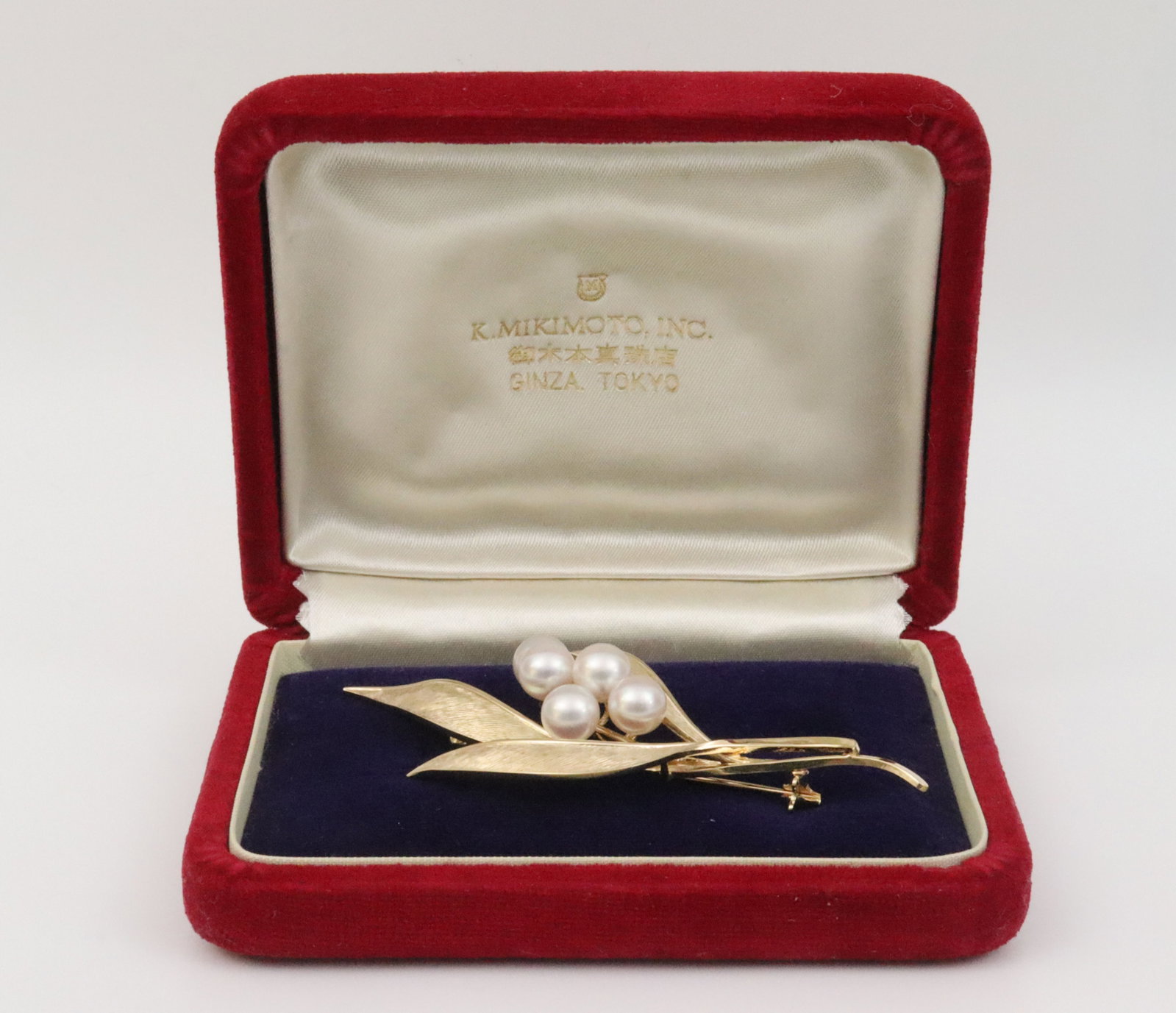 MIKIMOTO 14K LEAF PIN: featuring 5 (7mm) Akoya pearls, in yellow brushed gold, stamped 14K, and with Mikimoto maker's mark, 3.1x1.4in., accompanied by a red velvet presentation box from K. Mikimoto, Inc., Ginza, Tokyo,