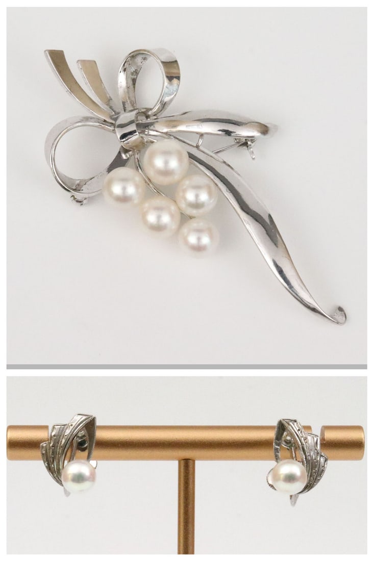 MIKIMOTO STERLING BOW PIN AND A PAIR OF EARRINGS: the pin featuring 5 (6mm) Akoya pearls, stamped 'S', and with Mikimoto maker's mark, 2.5x1.1in., together with a complementing pair of screwback earrings in carved ribbon design, each set with a