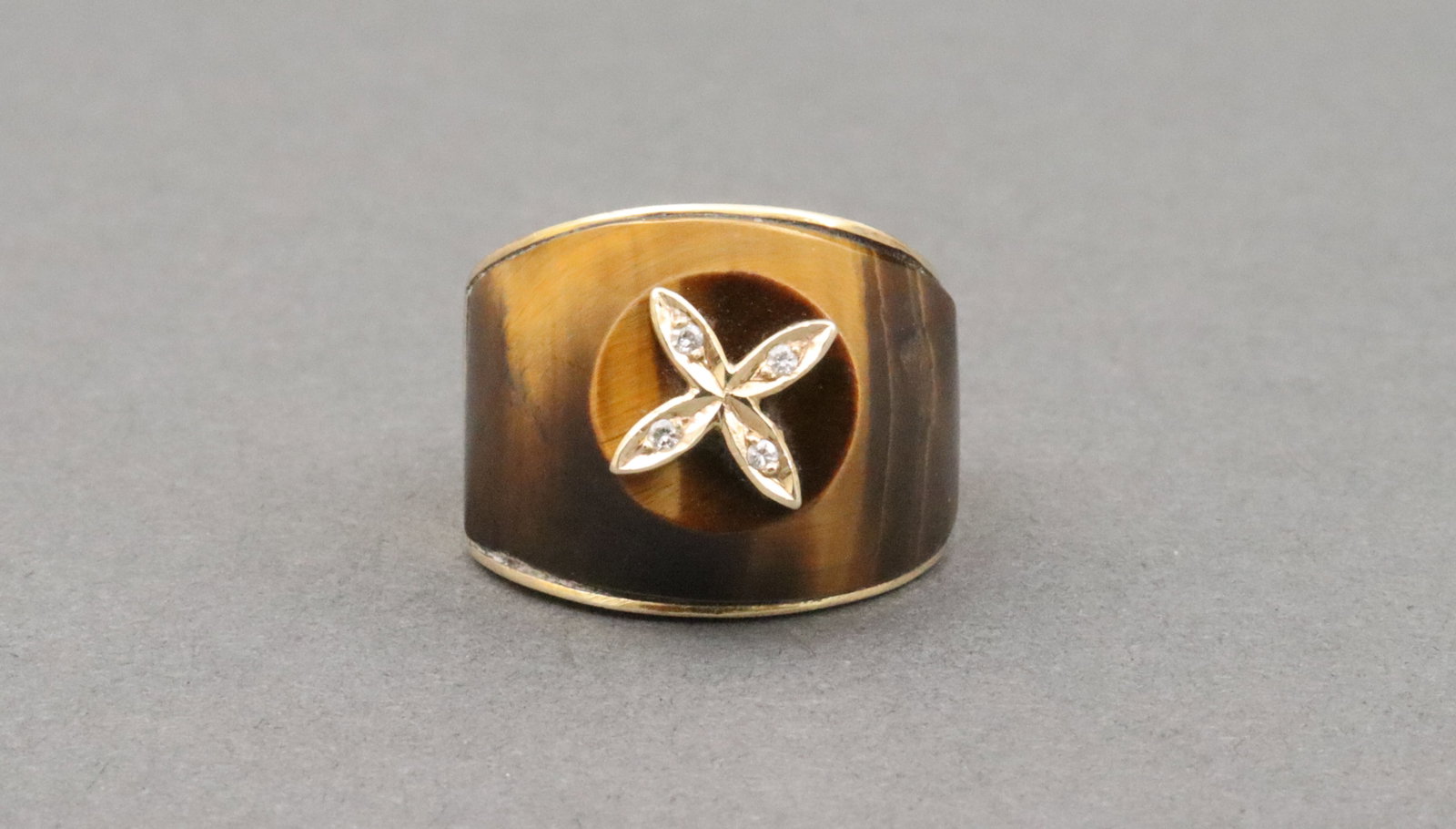 GENTS 14K TIGER EYE & DIAMOND COCKTAIL RING: custom cut tiger eye setting accented with 4 natural melee diamonds within an X-shape geometric, light rubs, height 14mm, in yellow gold, tests 10K (stamped 18K), size 8, 18.6gms., Opening Bid $700
