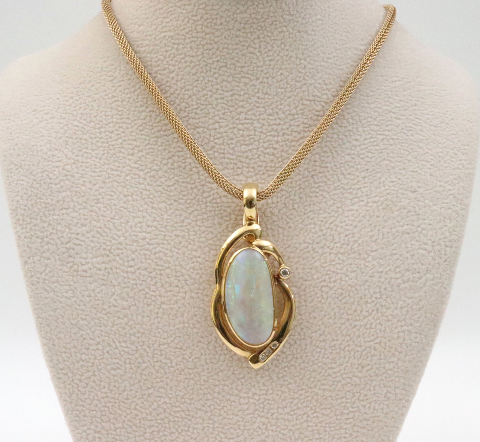 18K OPAL & DIAMOND PENDANT ON 14K CHAIN: the pendant features a (22x12mm) elongated oval opal cabochon (magnification reveals crazing to the opal), the freeform setting accented with 4 natural melee diamonds, the hinged bale with safety