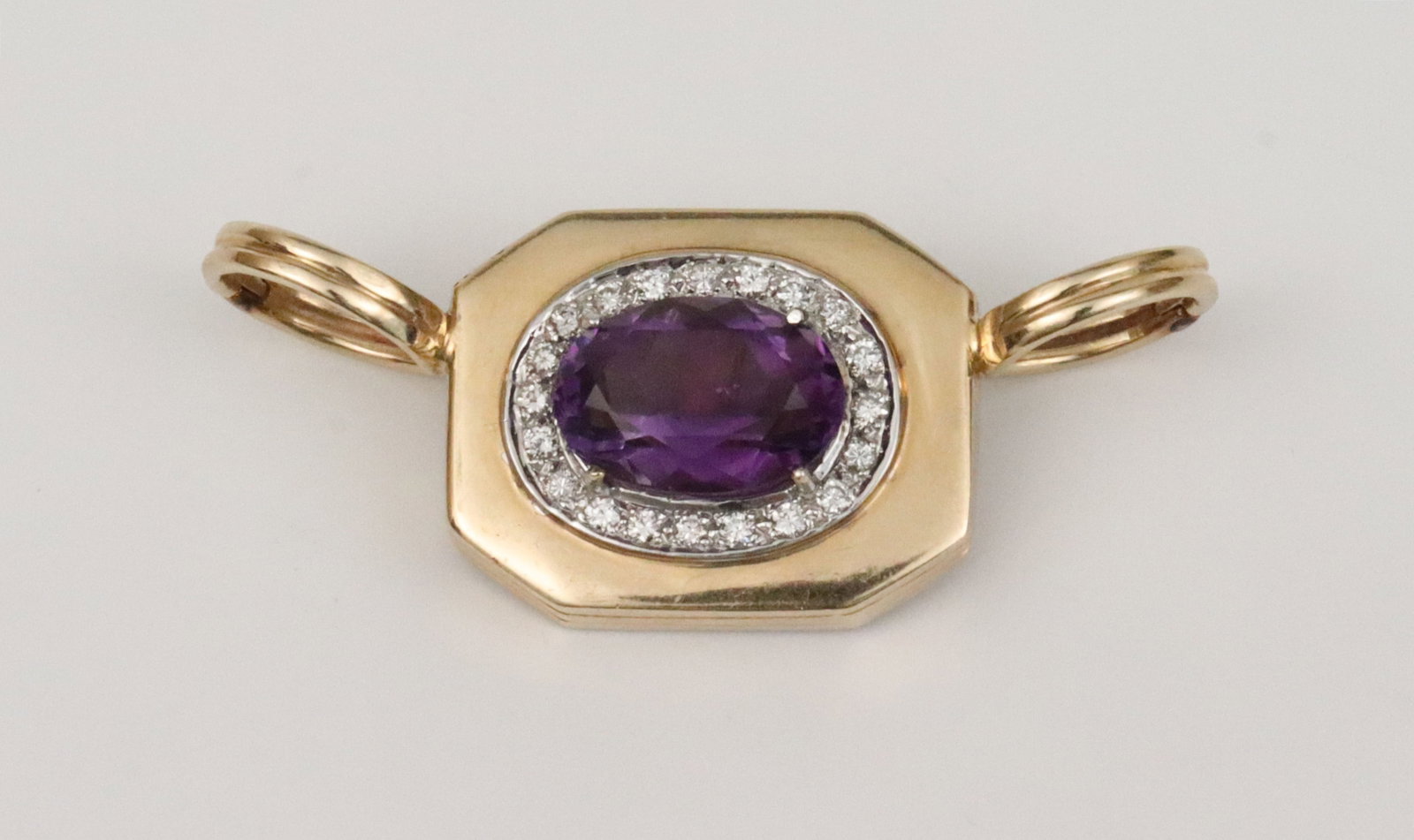 14K PURPLE GEMSTONE & DIAMOND ENHANCER: set with an oval (10x15mm) likely purple beryl stone (Refractive Index 1.581-1.583), centering 20 round natural diamonds approx. 0.60ctw, in yellow gold, tests 14K, overall .9x2.2in., 14.5gms.,