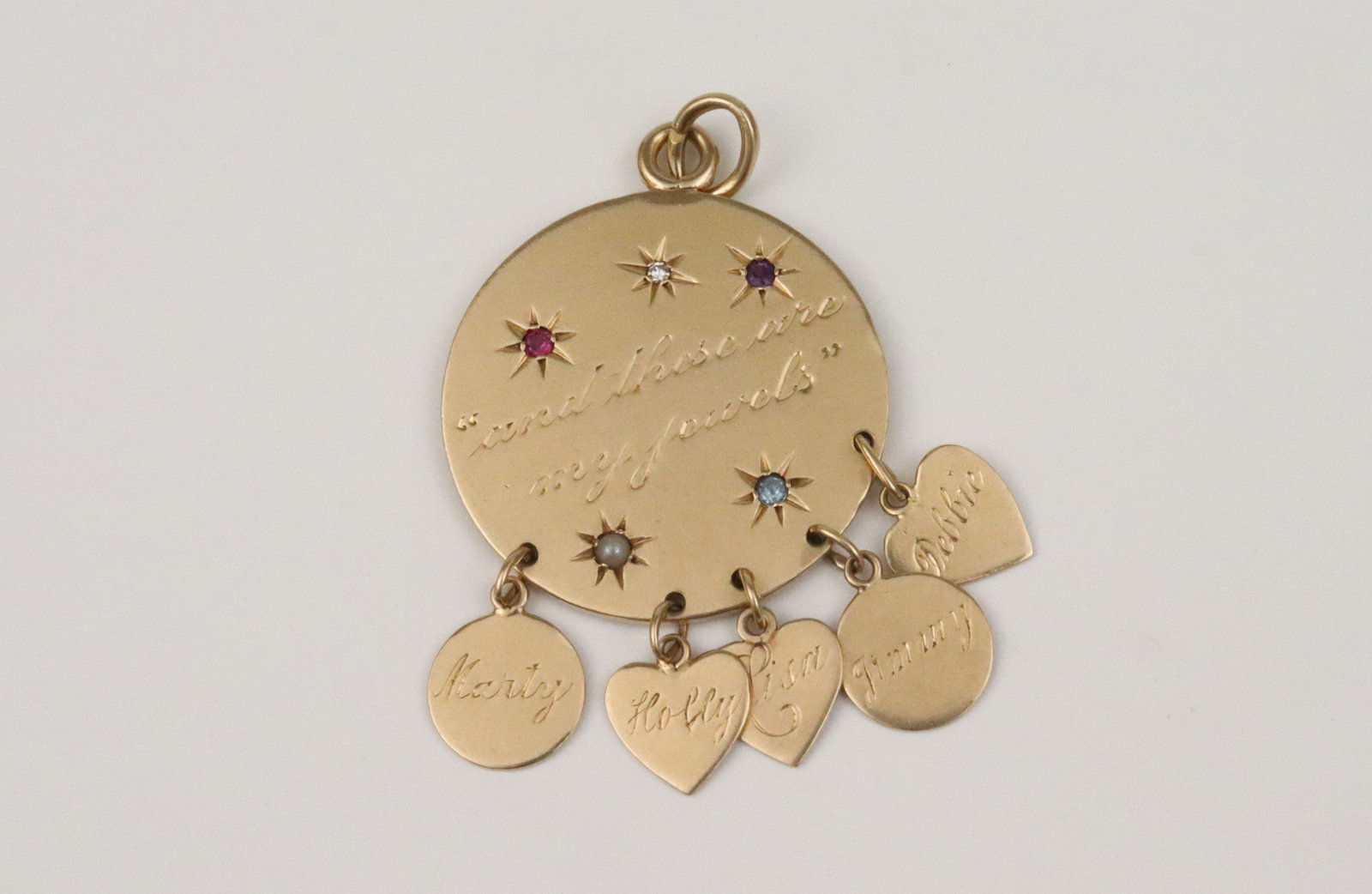 14K MOTHER'S PENDANT: the personalized disc pendant features 5 engraved starburst gemstones, and 5 dangling custom charms with names and birth dates ranging from 1959 to 1969, the disc engraved 'These are my Jewels', in ye