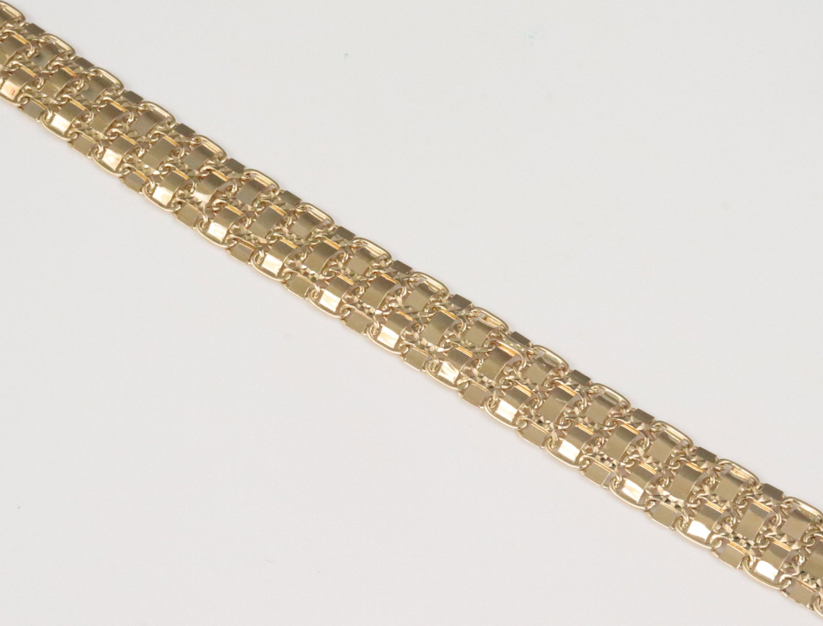 14K FANCY LINK BRACELET: in woven geometric design, in yellow gold, stamped '14K AK Turkey', width 11mm, length 7.25in., double safety catch, 12.5gms., Opening Bid $500