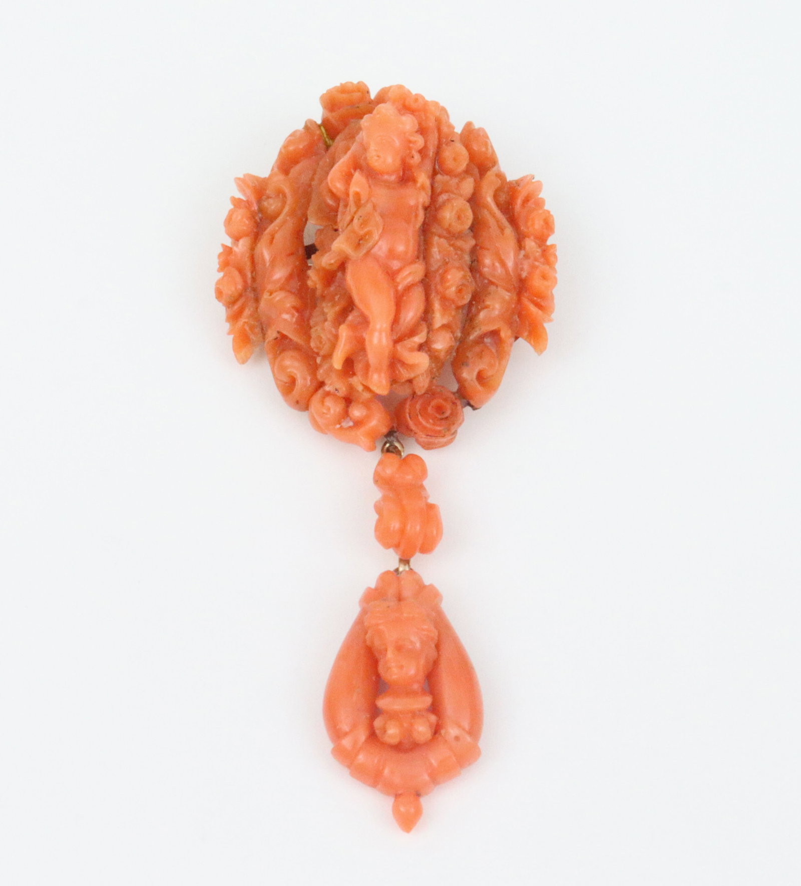 VICTORIAN CORAL CHERUB & FLORAL DANGLE BROOCH: gold-mounted carved salmon coral brooch with hinged pendant bale, tests 14K, some areas of restoration verso (more obvious under magnification), likely later added dangle, overall length 3in.,